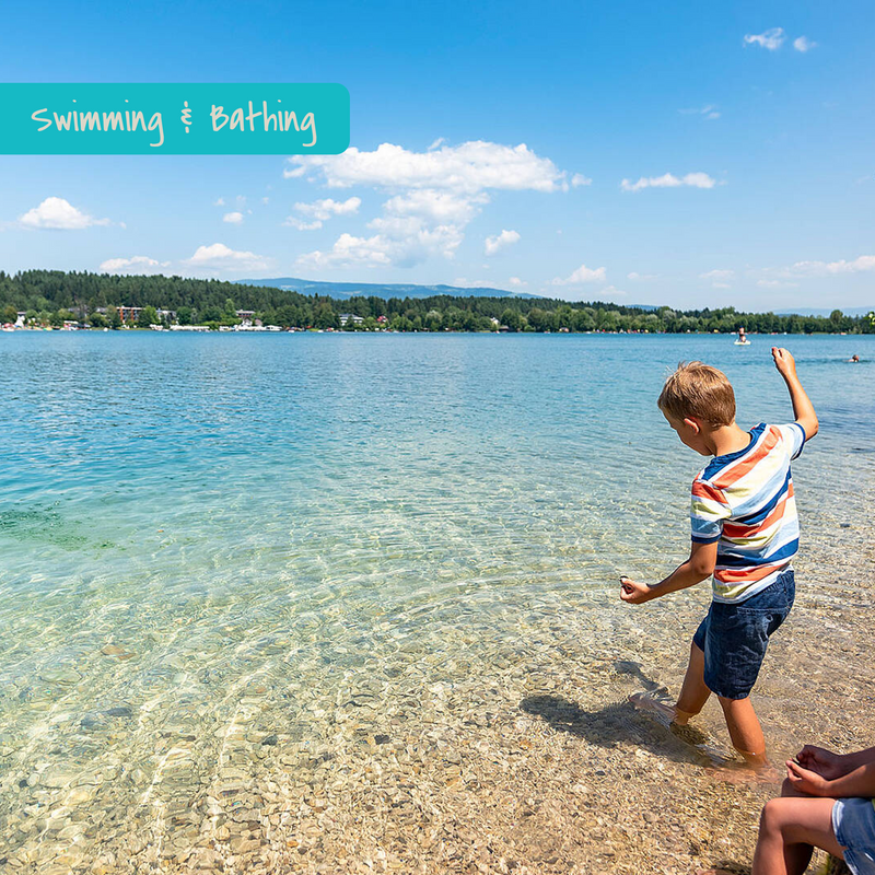 Child playing in crystal clear lake in Carinthia, Austria.